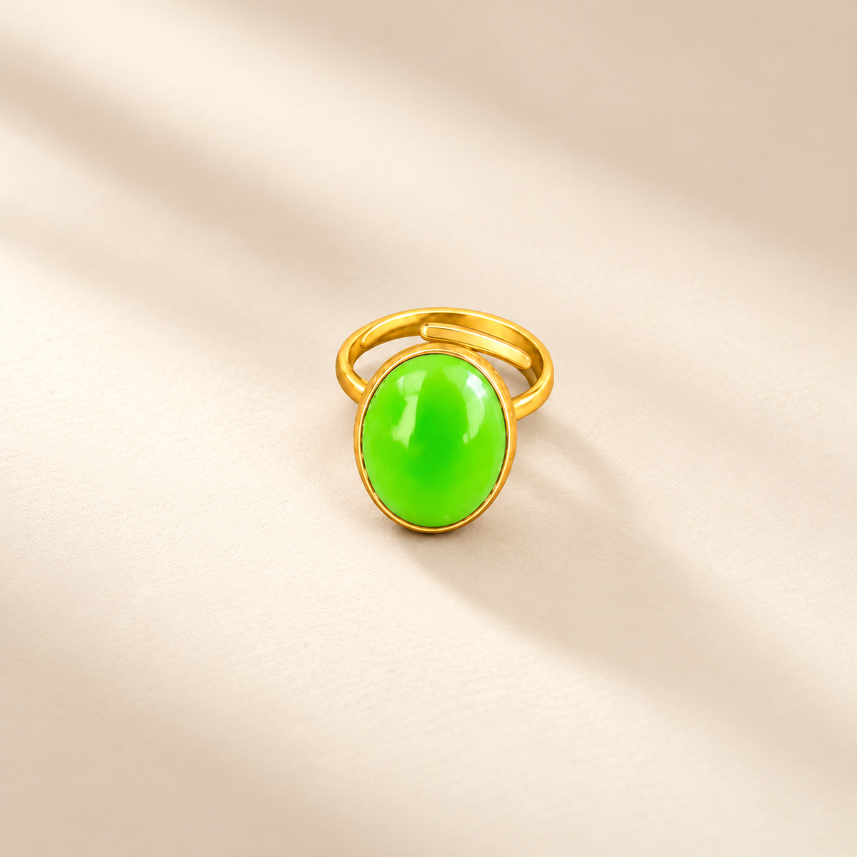 Éclat cow horn and brass ring in green, photographed on a smooth cream editorial background