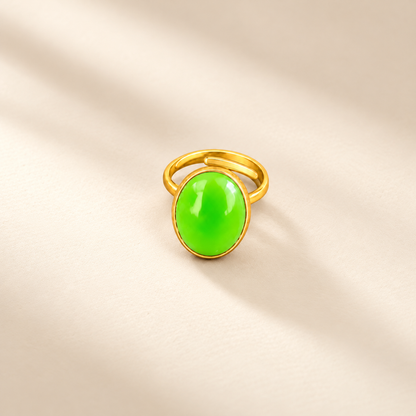 Éclat cow horn and brass ring in green, photographed on a smooth cream editorial background