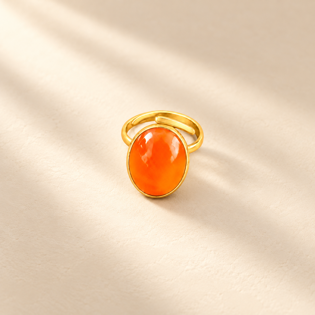 Éclat cow horn and brass ring in orange, photographed on a smooth cream editorial background