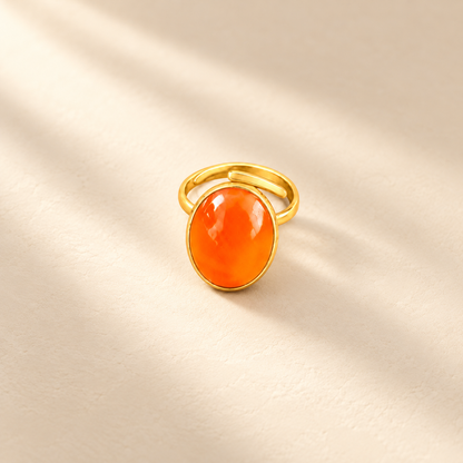 Éclat cow horn and brass ring in orange, photographed on a smooth cream editorial background