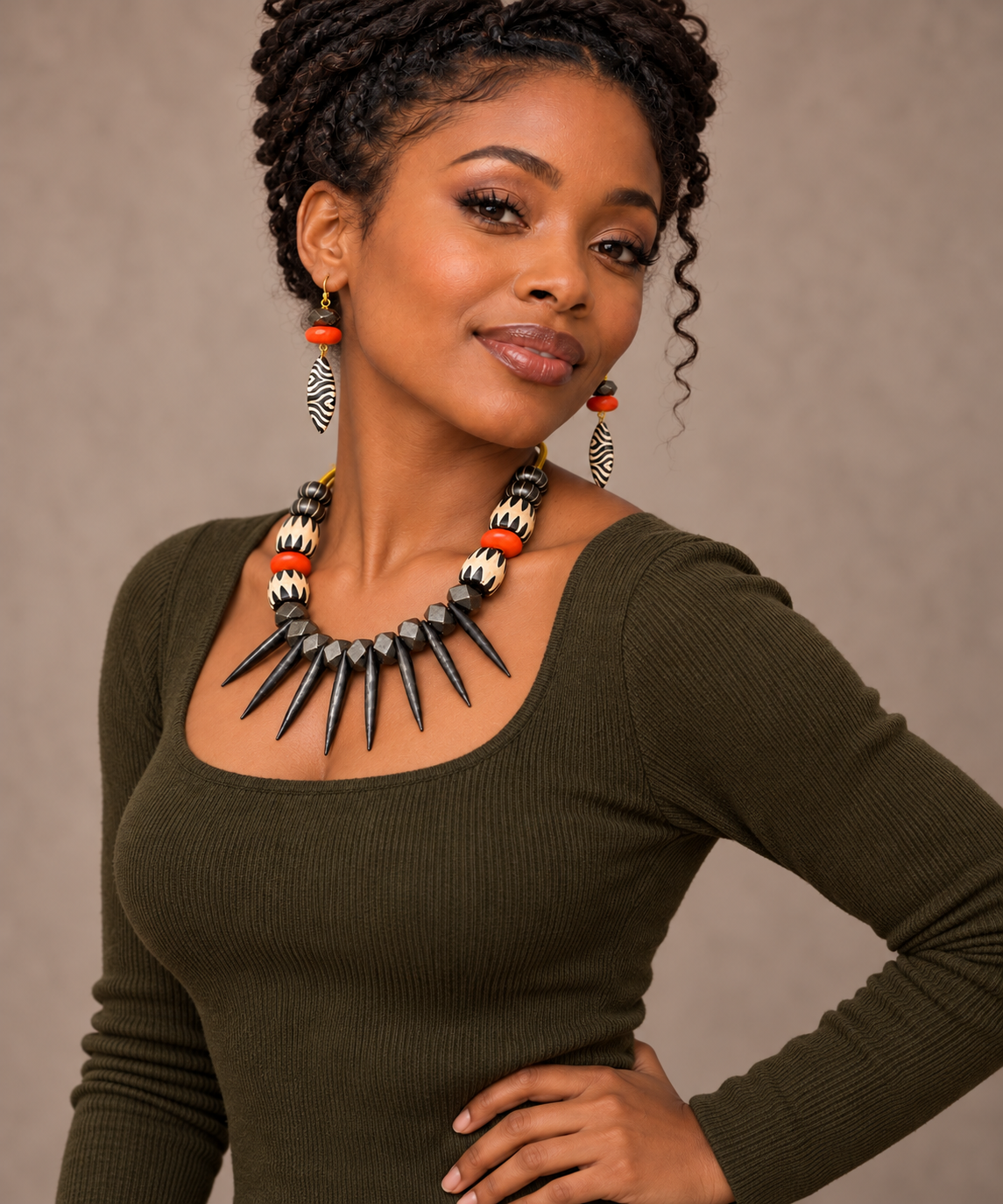 Model wearing the Ember Batik Statement Necklace and matching earrings with an olive fall top.